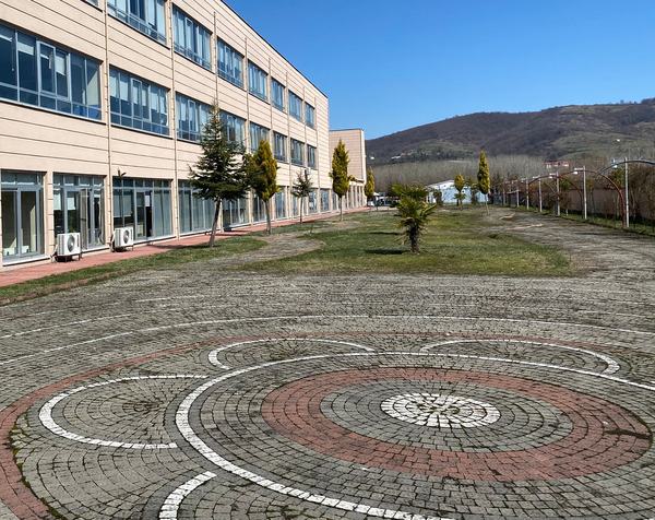 Taş döşeli desenli avlu ve uzun okul binası