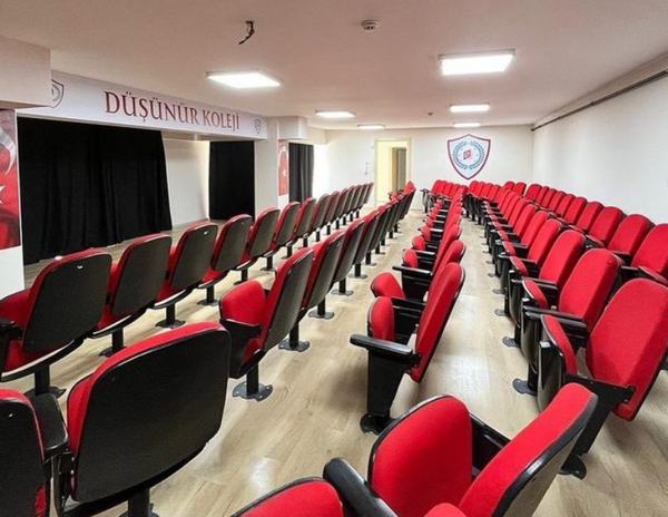 Sahneli konferans salonu ve kırmızı koltuk sıraları