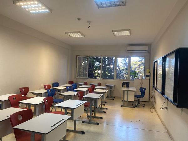 Ağaçlara bakan geniş pencereli lise dersliği