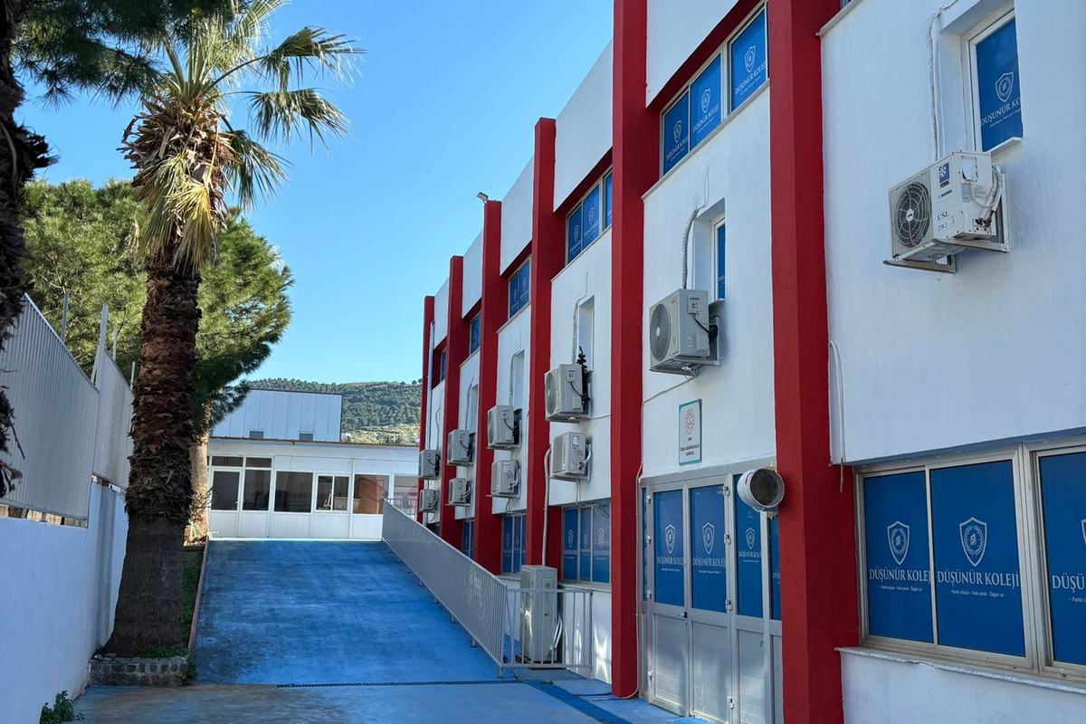 Güzelbahçe Kampüsü'nün kırmızı-beyaz cephesi ve yanındaki mavi rampa