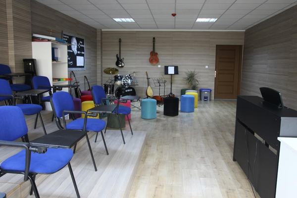 Bateri, gitarlar ve renkli puflarla donatılmış müzik atölyesi