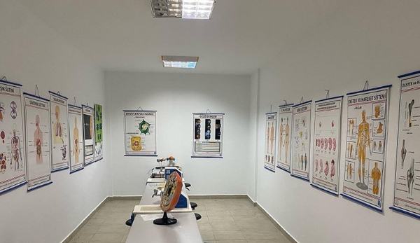 Anatomi posterleri ve hücre modeliyle donatılmış biyoloji laboratuvarı