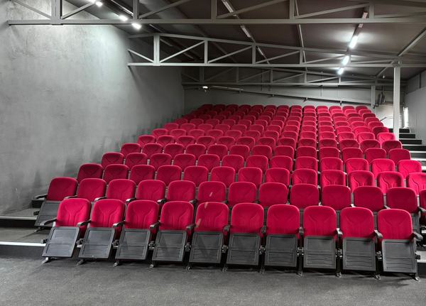 Kırmızı koltuklu, amfi düzenli konferans salonu
