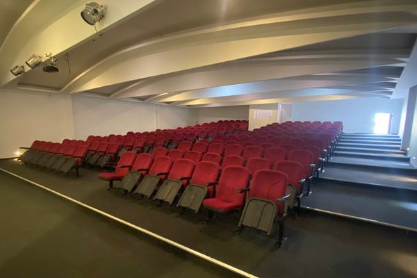 Kırmızı koltuklu, basamaklı konferans salonu