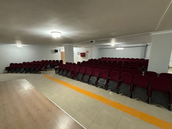 Bordo koltuklarla donatılmış geniş konferans salonu