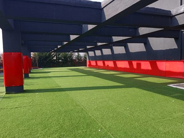 Pergola altında suni çim kaplı açık hava oyun alanı
