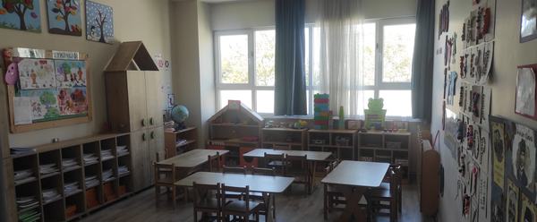 Oyun köşeleri ve etkinlik panosu bulunan anaokulu sınıfı
