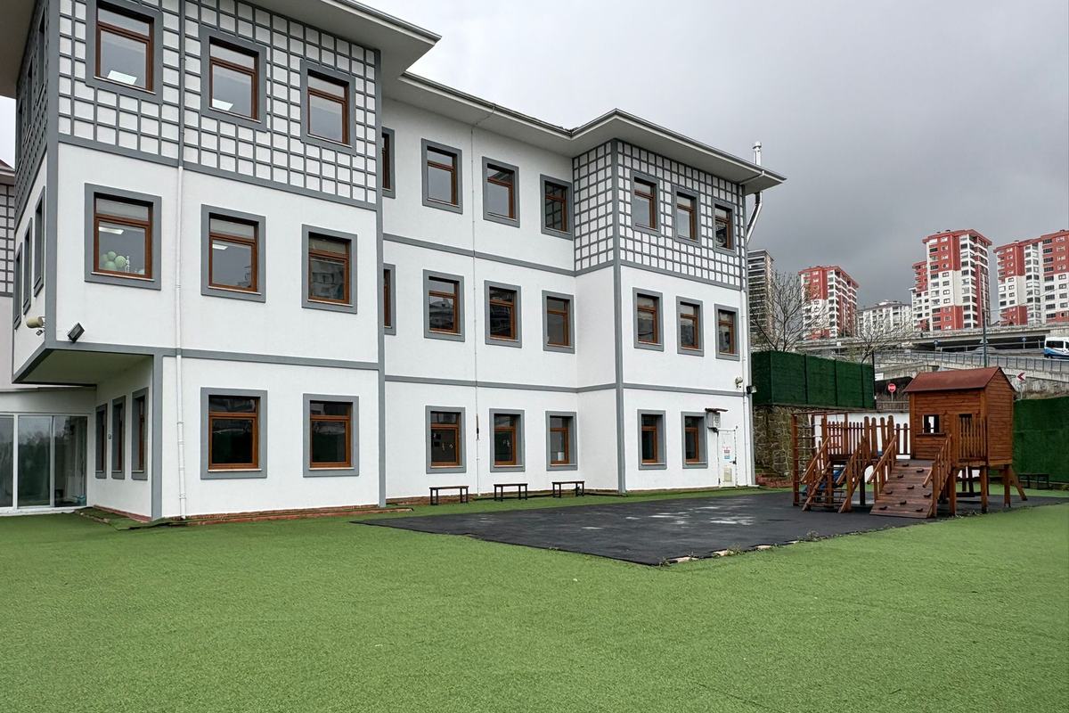 Geleneksel Trabzon evi mimarisindeki okul binası, çim bahçe ve oyun parkı